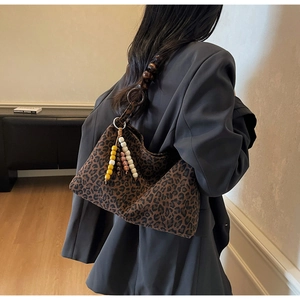 Détail du sac léopard avec bandoulière en perles de bois marron et pompon coloré