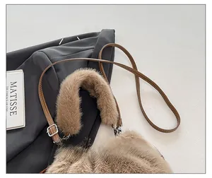 Close-up of fluffy light brown plush bag with adjustable brown leather shoulder strap