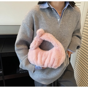 Dettaglio della morbida pelliccia sintetica rosa di una borsa a mano autunnale