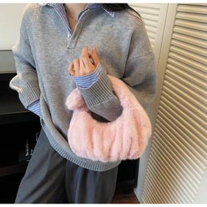 Dettaglio della borsa hobo in ecopelliccia rosa con strisce verticali e morbida texture