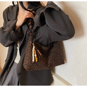 Detail der Vintage-Leoparden-Tasche mit Holzperlengriff und stilvollem Perlenanhänger