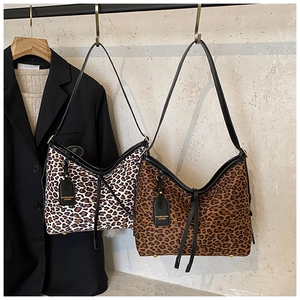 Detail view of large leopard print tote bags in light and dark brown with leather straps