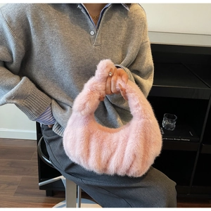 Dettaglio ravvicinato della borsa in ecopelliccia rosa con elegante manico a nodo