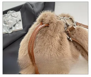 Detail of drawstring closure on brown faux fur bucket bag with leather strap and metal hook