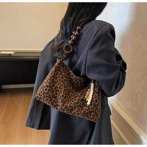 Détail du sac cabas léopard avec bandoulière en perles de bois et breloque à pompon