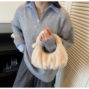 Dettaglio della borsa hobo in ecopelliccia beige con design a pieghe per stile invernale