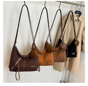 Detail of four matte vintage tote bags hanging with round coin purses and metal zippers