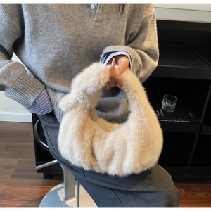 Dettaglio della borsa in pelliccia sintetica con elegante manico a nodo moda