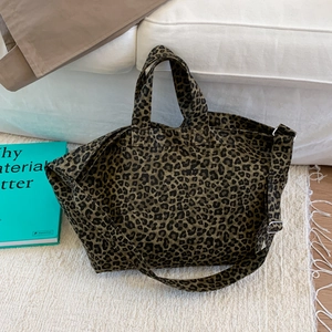 Detail of leopard print canvas tote bag with adjustable shoulder strap and silver hardware