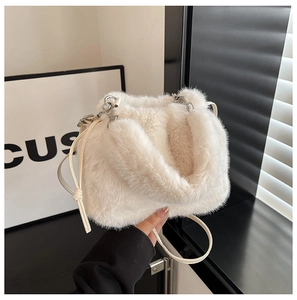 Détail du sac seau en fausse fourrure crème avec cordon de serrage et boucle argentée