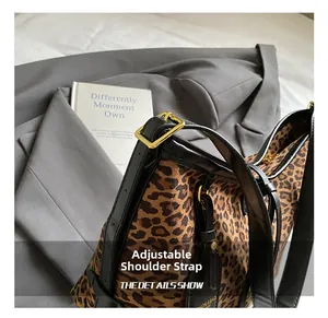 Detail of adjustable black leather strap and golden metal buckle on leopard tote bag