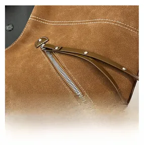 Detailed close-up of brown suede bag with silver zipper and white contrast stitching