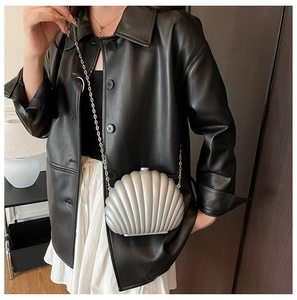 Sac bandoulière coquillage argenté avec chaîne en métal porté par un mannequin
