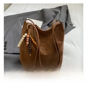 Detail of leopard print bucket bag featuring retro wooden bead tassel and soft suede texture