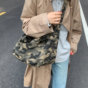 Macro shot of large-capacity canvas crossbody bag in jungle camouflage pattern