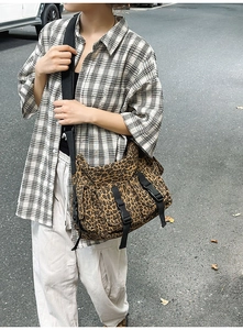 Detail der Tragetasche mit Leopardenmuster, schwarzen Nylonschnallen und Streetstyle-Look