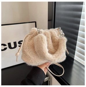 Gros plan détaillé du sac seau beige en fausse fourrure douce avec une chaîne argentée