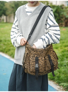 Detail der Canvas-Einkaufstasche mit Leopardenmuster, Multi-Pocket-Design und schwarzen Schnallen