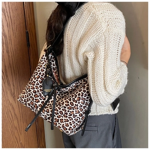 Detail of leopard print hobo bag showing the leather drawstring and texture on a shoulder