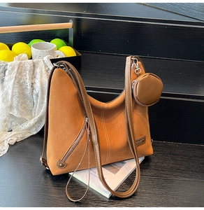 Detail of brown frosted hobo bag with side zipper, mini coin purse and contrast stitching