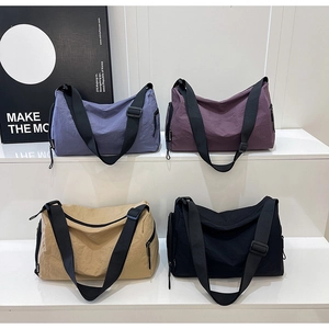 Detail of multi-color nylon crossbody bags in blue, purple, khaki, and black options