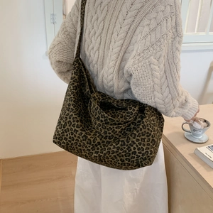 Detail of wide shoulder strap on leopard print canvas tote bag with moss green finish