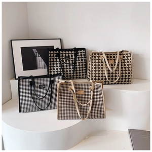 Detail of four checkered tote bags in houndstooth and diamond patterns on display