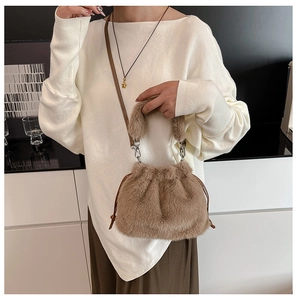Detail of soft faux fur shoulder bag with leather strap and plush handles on model