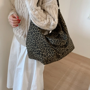 Close-up of leopard print canvas tote bag texture with wide shoulder strap design