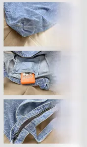 Detail view of denim tote bag showing internal pocket, zipper, and fine stitching quality