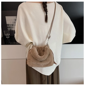 Detailed view of the soft brown faux fur crossbody bag with leather strap on a model