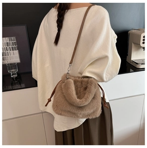 Détail d'un sac seau en peluche marron avec cordon de serrage et bandoulière en cuir