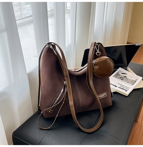 Detail of vintage brown tote bag featuring contrast stitching and detachable round coin purse