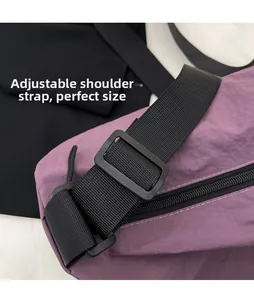 Detail of adjustable wide black strap and buckle on purple nylon crossbody bag