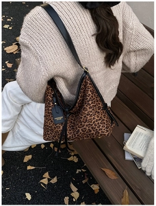 Chic leopard print shoulder bag worn by model on park bench during autumn season