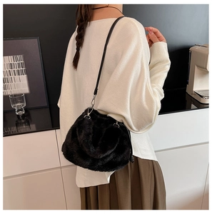 Détail du sac à bandoulière en fausse fourrure noire avec fine lanière en cuir