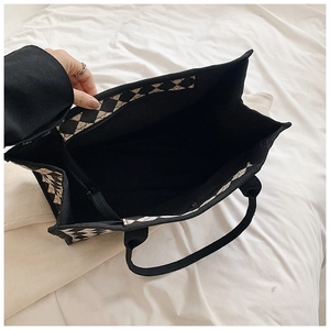 Top view of spacious checkerboard tote interior featuring black lining and zipper pocket