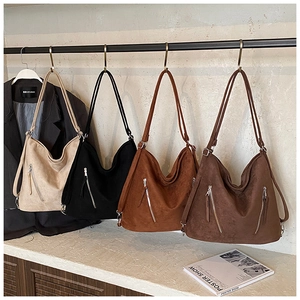 Détail de grands sacs hobo en daim avec poches à fermeture éclair en diverses couleurs