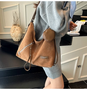 Brown faux suede hobo bag with a matching coin purse shown on a model's shoulder