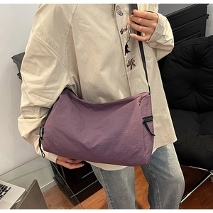Detailed view of dark purple waterproof nylon crossbody bag with fashion side label