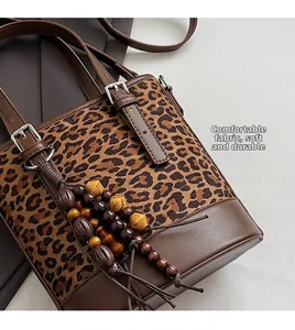 Detail der Leoparden-Beuteltasche mit Holzperlen-Quaste und weicher Lederstruktur