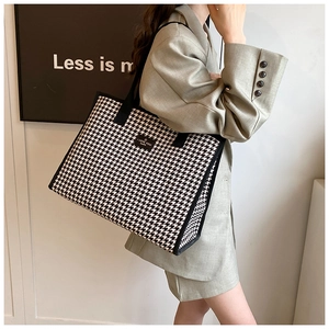 Detailed view of large checkered tote bag with woven texture and black label detail