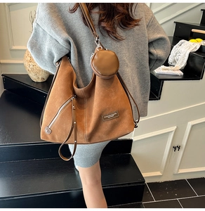 Detail of vintage brown suede tote with silver zipper pocket and round coin pouch charm