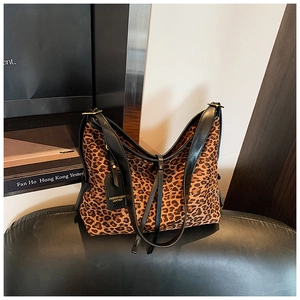 Detailed view of leopard print tote bag with black leather straps and fashion tag