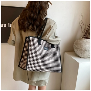Detail of classic black and white houndstooth canvas tote bag with woven texture