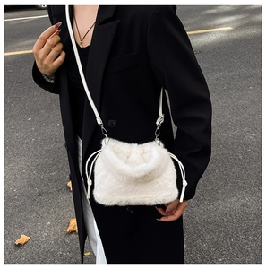 Détail d'un sac bandoulière blanc en peluche avec fermeture à cordon et fine lanière