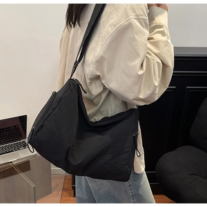 Close-up of black large capacity nylon crossbody hobo bag with adjustable wide shoulder strap