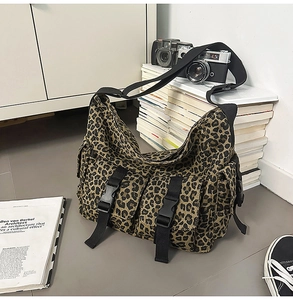 Detailansicht der Leopard-Umhängetasche mit Schnallentaschen und schwarzem Schultergurt