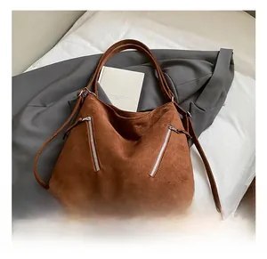 Détail du sac cabas en daim caramel avec doubles fermetures éclair et bandoulière large