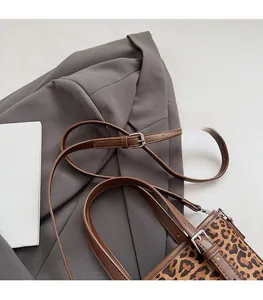 Detail eines verstellbaren Leder-Schultergurts mit Silberschnalle an einer Handtasche
